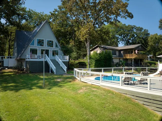 a view of a house with swimming pool and yard