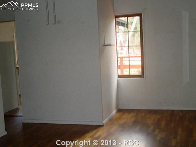 9390 Mountain Road Cascade, CO 80809 - Photo 2 of 7 a view of an empty room with wooden floor and a window