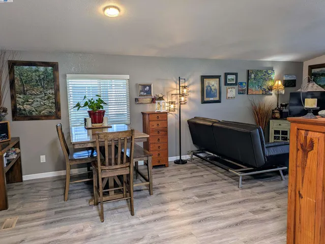 a living room with furniture a dining table and a window