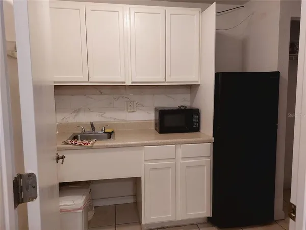 a kitchen with white cabinets and sink
