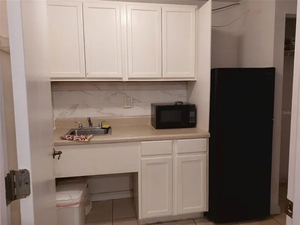 a kitchen with white cabinets and sink