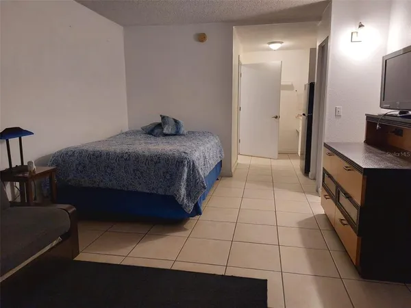 a bedroom with a bed and a view of kitchen
