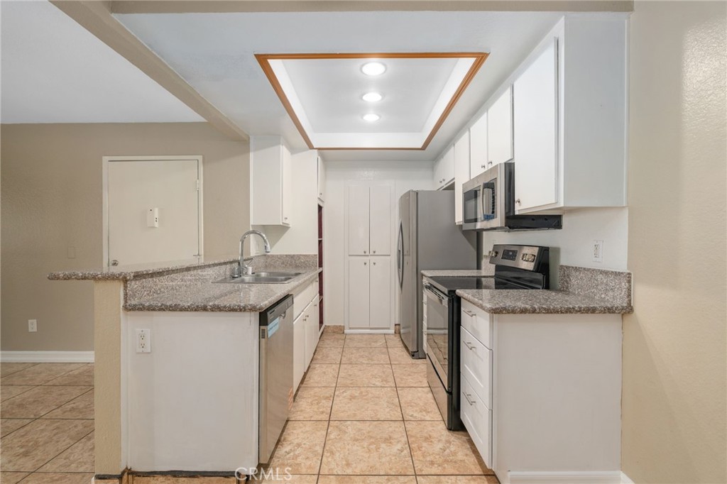 3535 Banbury Drive, Unit 119 Riverside, CA 92505 - Photo 8 of 23 a kitchen with stainless steel appliances granite countertop a sink and cabinets
