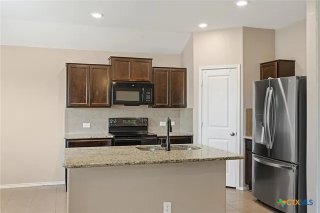 a kitchen with refrigerator cabinets and stainless steel appliances