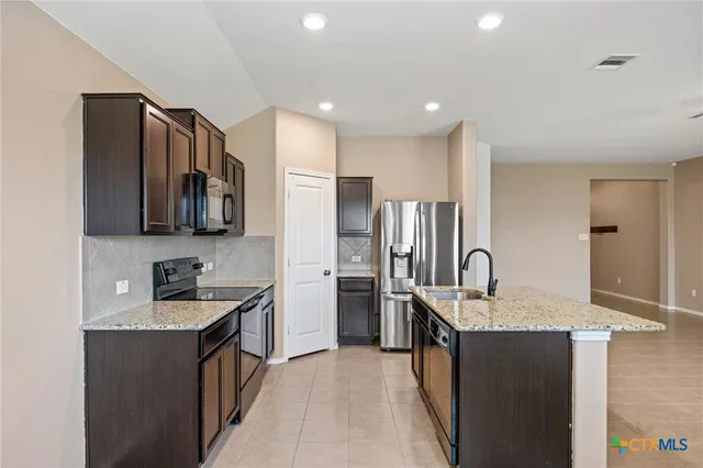 a kitchen with a sink a microwave and refrigerator