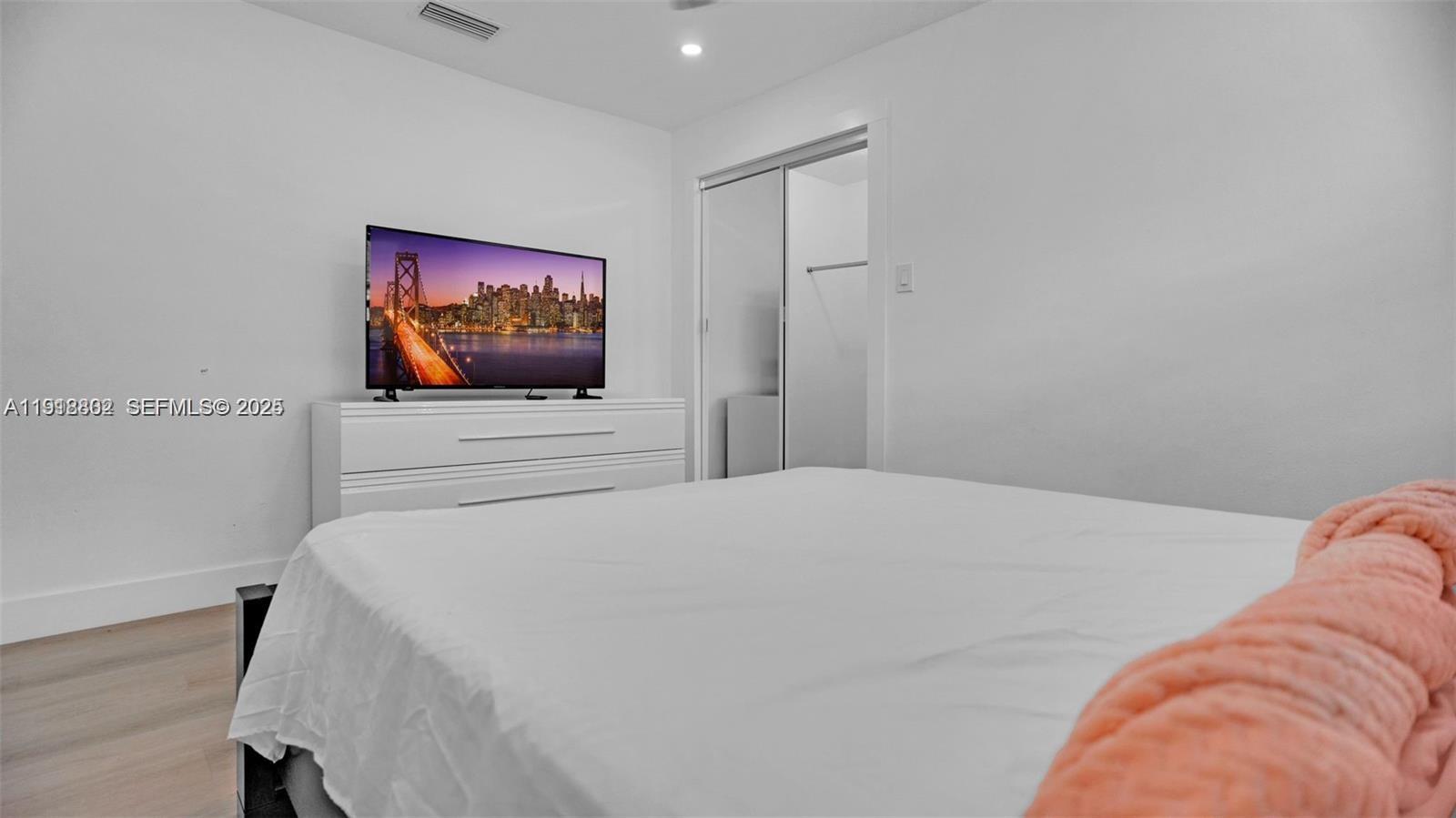 32 Southwest 9th Street, Unit 3 Hallandale Beach, FL 33009 - Photo 9 of 13 a bedroom with a bed and a flat screen tv