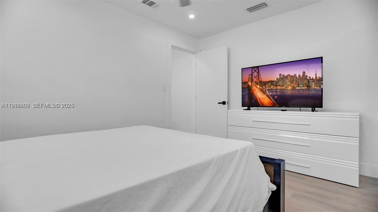 32 Southwest 9th Street, Unit 3 Hallandale Beach, FL 33009 - Photo 10 of 13 a bedroom with a bed and a flat screen tv