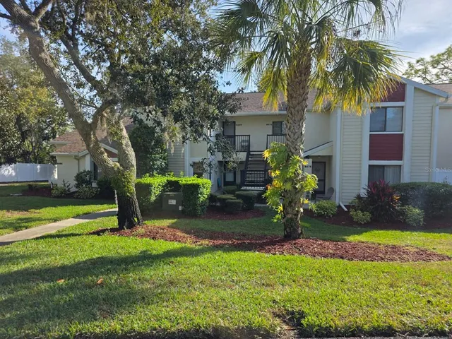 a view of a house with a yard and a tree