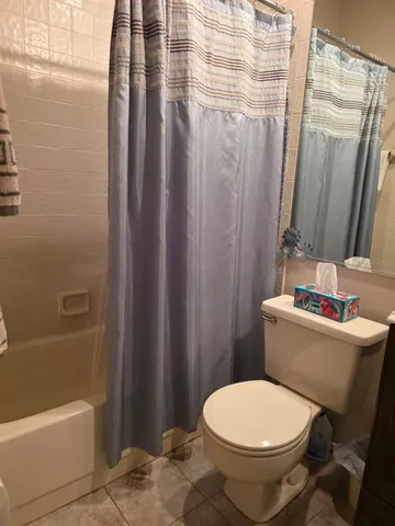 a white toilet sitting next to a bath tub