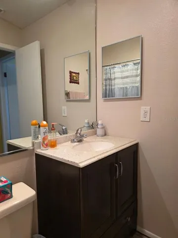 a bathroom with a toilet sink and mirror