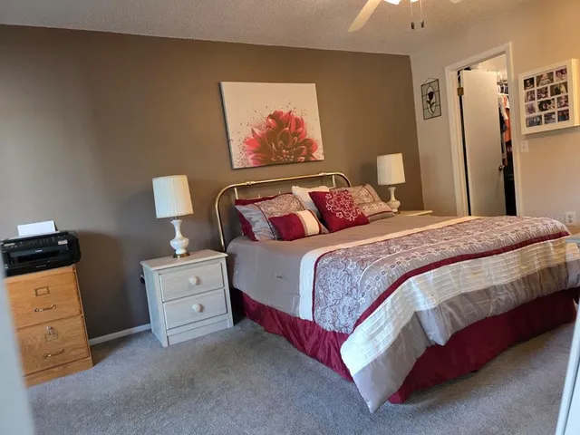 a bedroom with a bed and a refrigerator