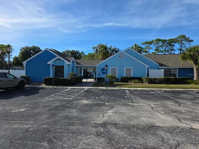 a front view of a house with a yard and parking space