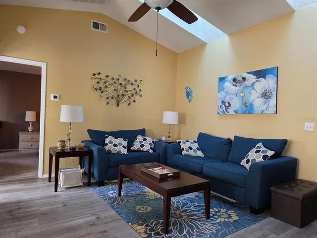 a living room with furniture a rug and a wall painting