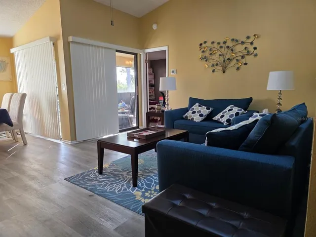 a living room with furniture a window and a wooden floor