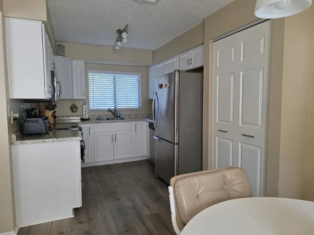 a kitchen with stainless steel appliances a refrigerator sink and cabinets