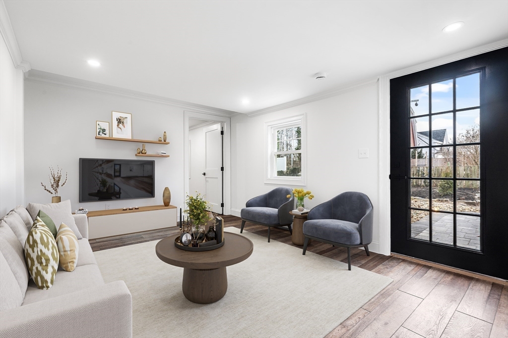 a living room with furniture a flat screen tv and a large window