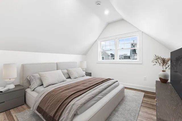 a kitchen with stainless steel appliances granite countertop a stove top oven a refrigerator and white cabinets with wooden floor