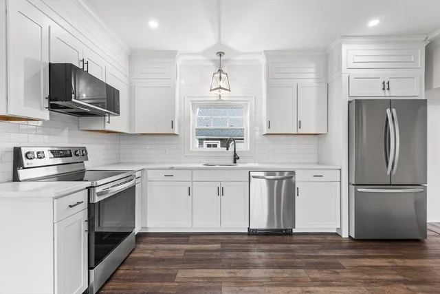 a kitchen with granite countertop a refrigerator and a sink