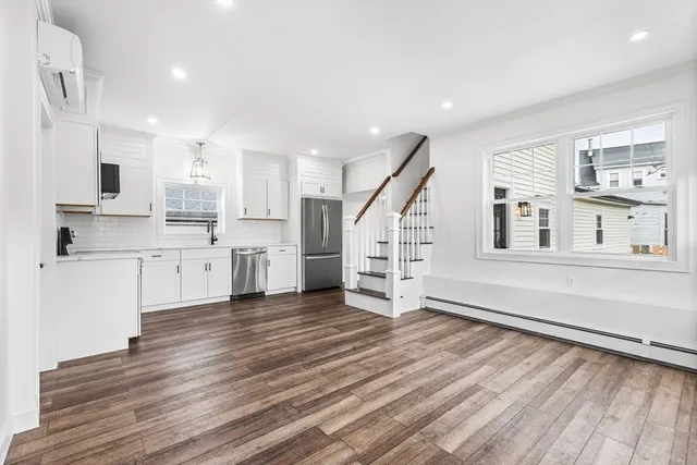 a view of kitchen with wooden floor and electronic appliances