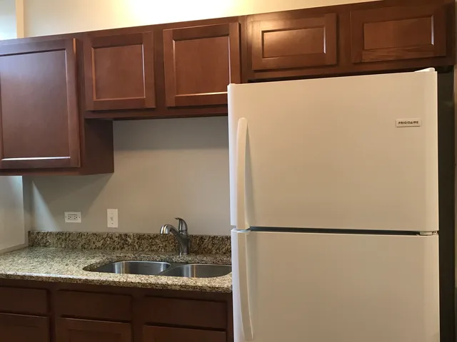 a kitchen with granite countertop cabinets and refrigerator