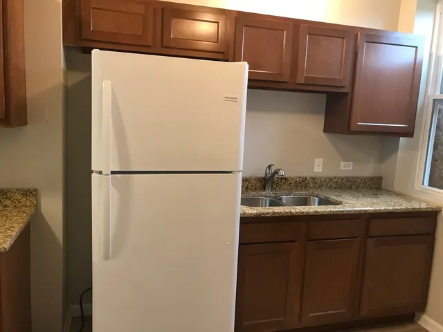 a kitchen with stainless steel appliances granite countertop a refrigerator and a sink