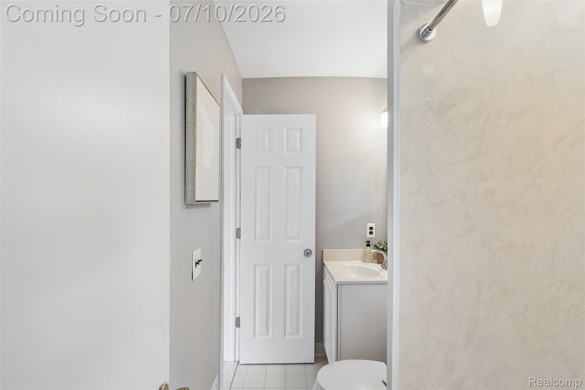 42698 Keystone Canton, MI 48187 - Photo 18 of 33 Bathroom featuring a white vanity with a countertop sink, neutral wall color, white paneled door, and tiled flooring
