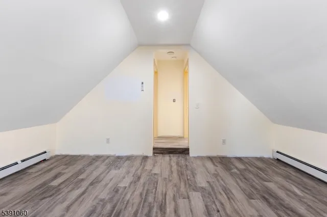 an empty room with wooden floor and white walls