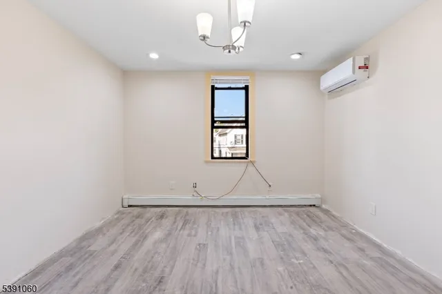 an empty room with wooden floor and ceiling fan