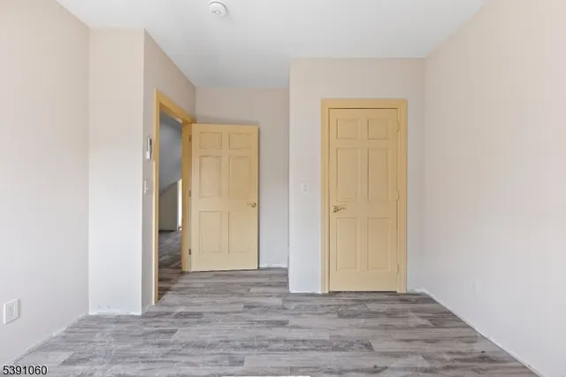 an empty room with wooden floor and closet