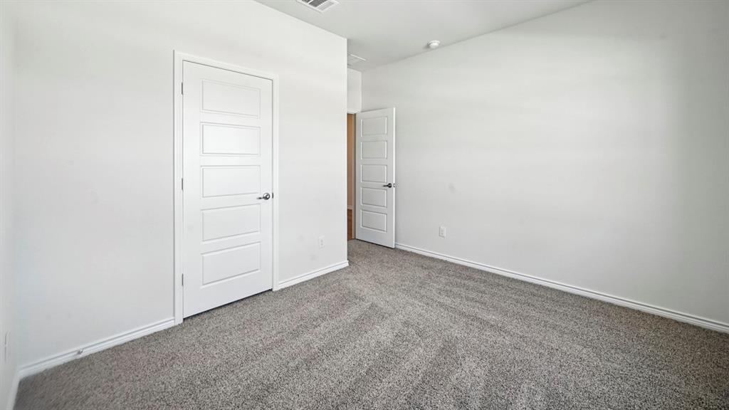 412 Carthage Street Caddo Mills, TX 75135 - Photo 29 of 32 Neutral color palette featuring light gray carpet, white baseboards, and white walls