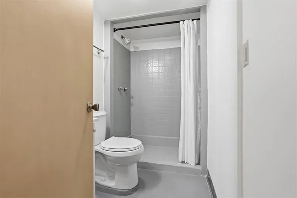a bathroom with a toilet and a shower