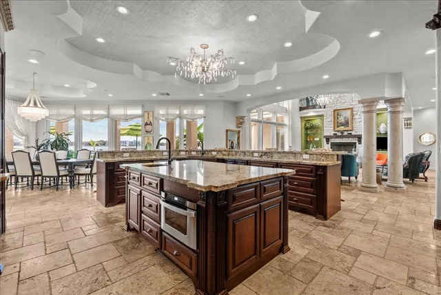 a kitchen with stainless steel appliances granite countertop a stove top oven a kitchen island a sink a counter top and cabinets