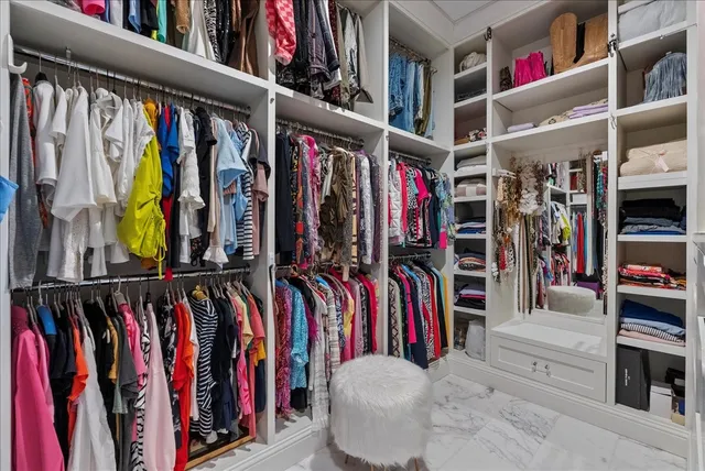 a view of walk in closet with clothes