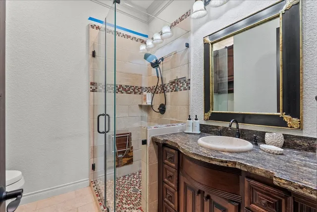 a bathroom with a granite countertop shower sink and mirror
