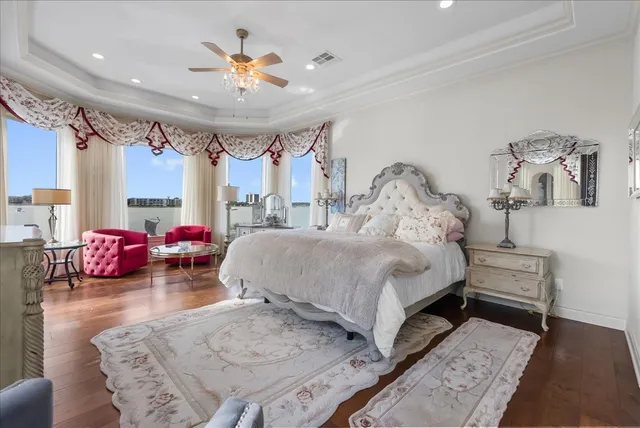 a spacious bedroom with a bed a couch and a chandelier