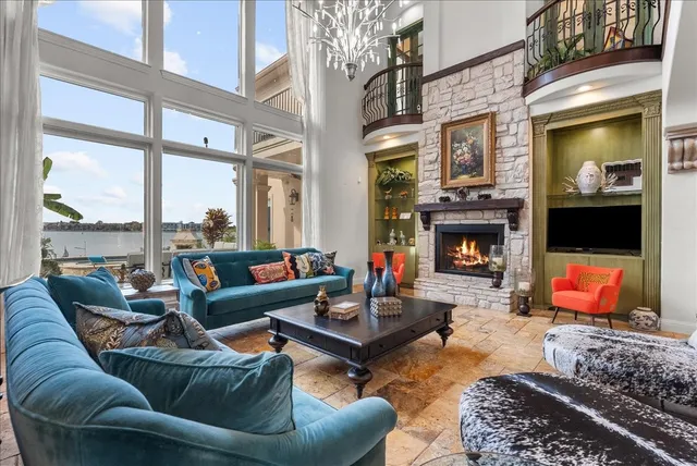 a living room with furniture a fireplace and a large window