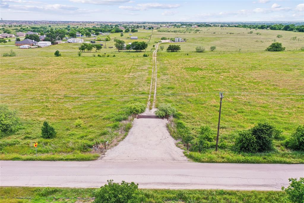 Tbd Seaborn Road Ponder, TX 76259 - Photo 9 of 12 Expansive open field with a defined gravel entry, surrounding green landscape, and distant residential structures