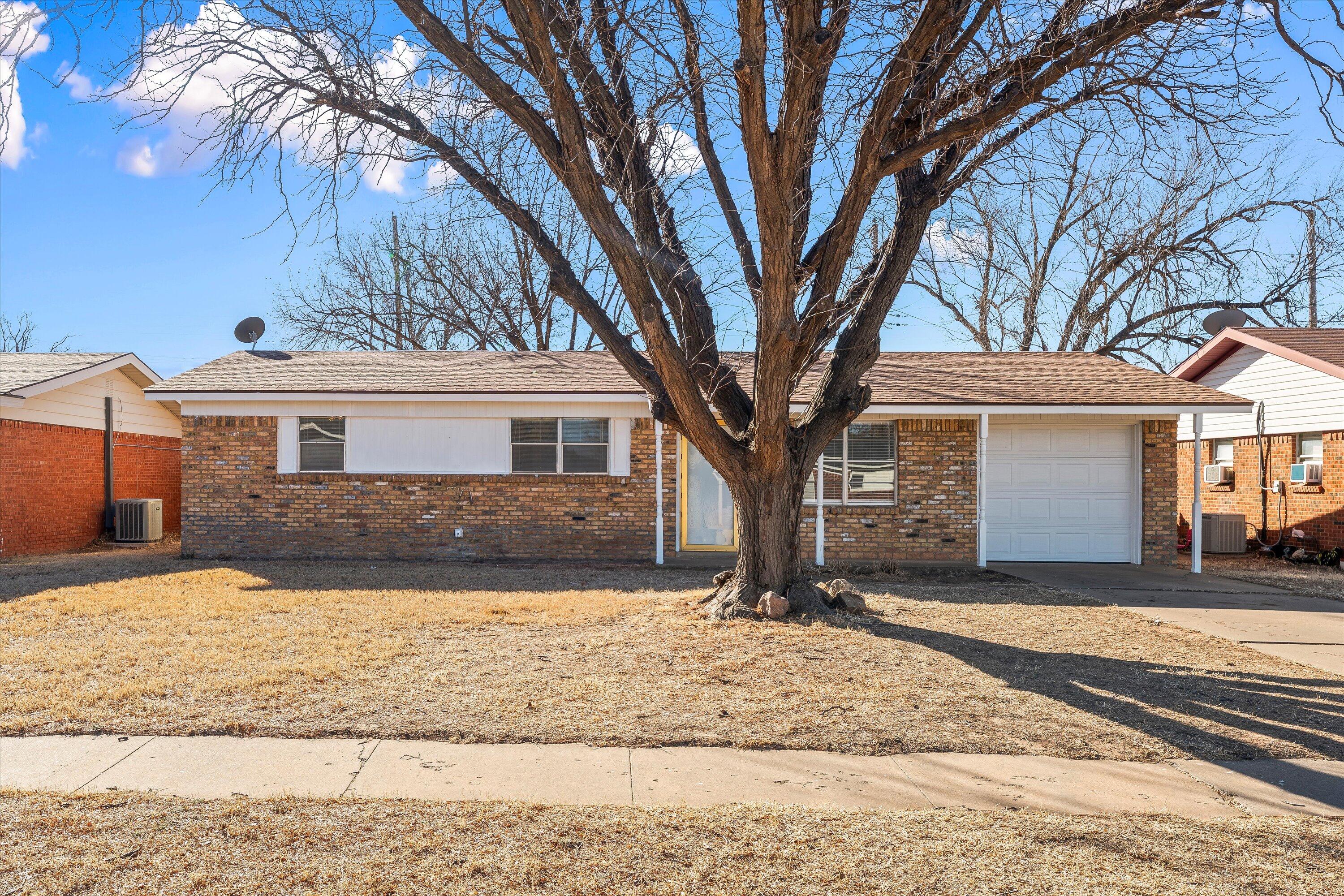 5519 17th Street Lubbock, TX 79416 - Photo 3 of 23 a front view of a house with a yard covered with snow and trees