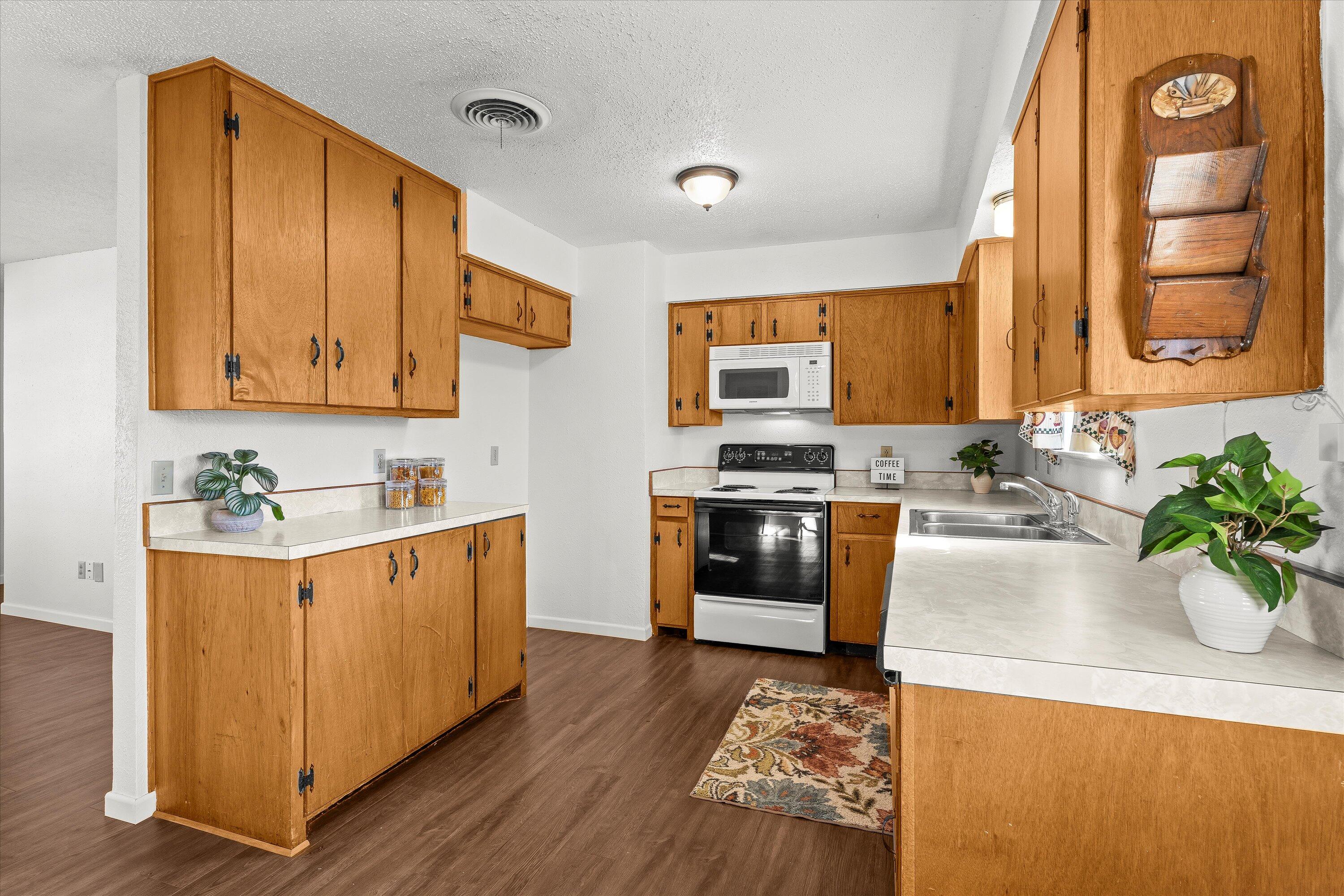 5519 17th Street Lubbock, TX 79416 - Photo 8 of 23 a kitchen with stainless steel appliances granite countertop a stove a sink a refrigerator and a microwave