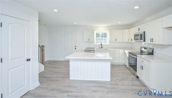 a kitchen with white cabinets appliances and sink