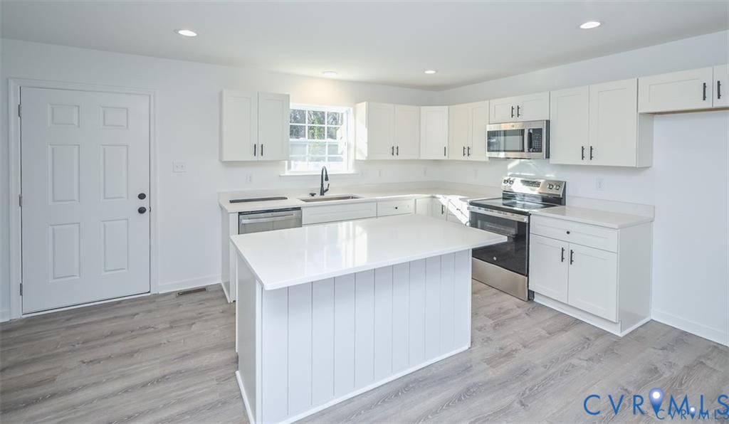352 Ogden Street West Point, VA 23181 - Photo 9 of 29 a kitchen with stainless steel appliances granite countertop a sink stove and wooden floor