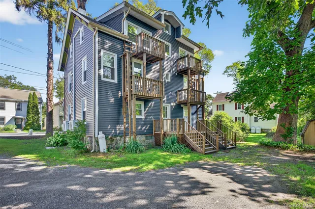 a view of a house with a small yard and wooden stairs