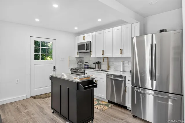 a kitchen with stainless steel appliances a stove sink microwave refrigerator and cabinets