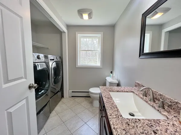 a en suite bathroom with a tub double sink and a mirror
