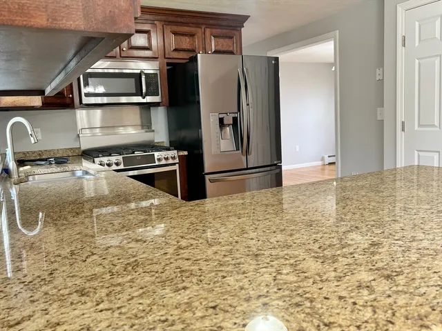 a kitchen with granite countertop a stove and a refrigerator