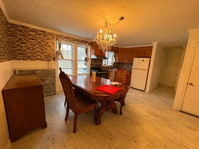 a dining room with furniture a rug and a chandelier