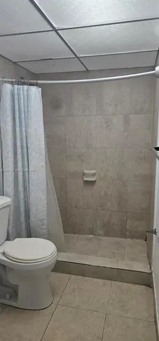 a white toilet sitting next to a bath tub