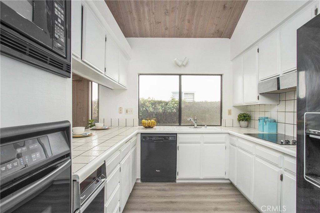 11 Ensueno Irvine, CA 92620 - Photo 9 of 36 a kitchen with a sink a stove and cabinets