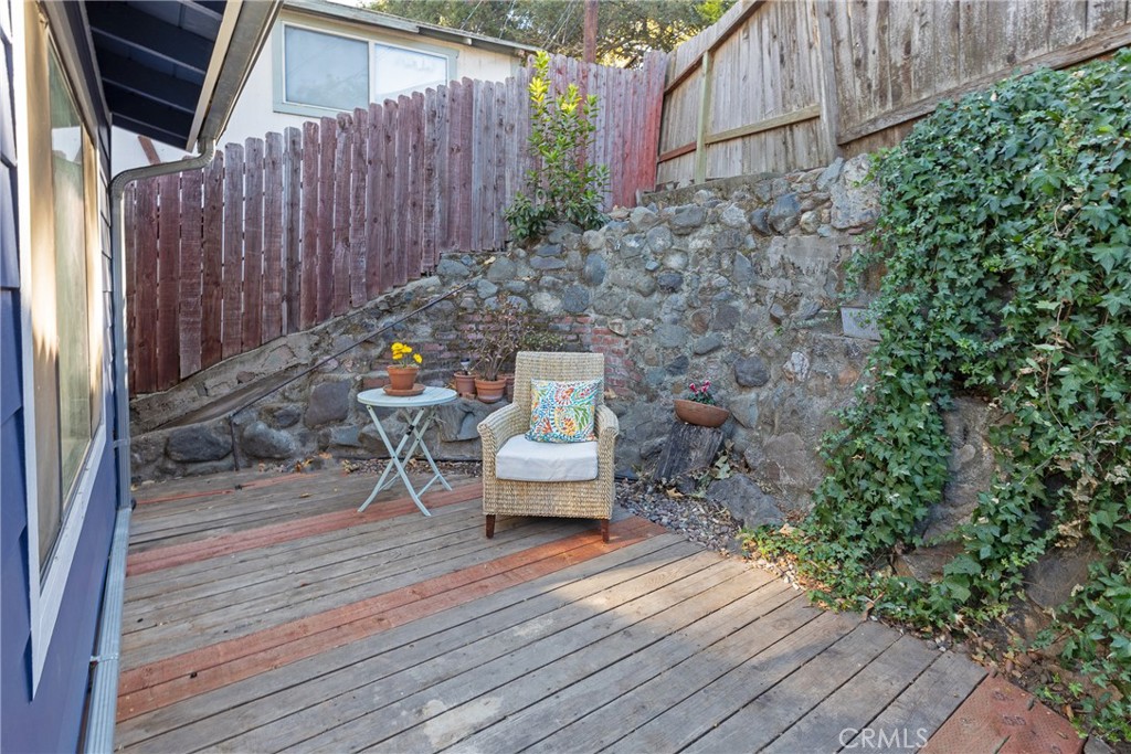 28344 Water Way Silverado, CA 92676 - Photo 25 of 34 a wooden bench sitting in backside of a house with potted plants