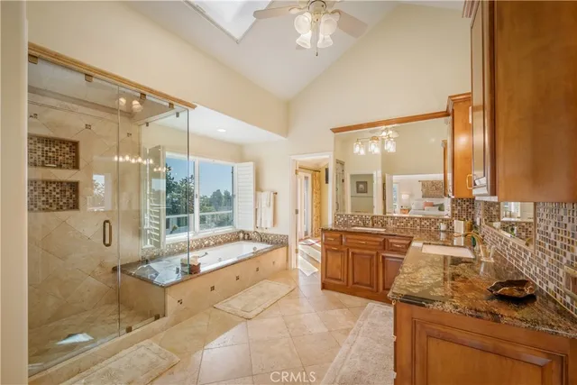 a large bathroom with a granite countertop tub sink shower and a mirror
